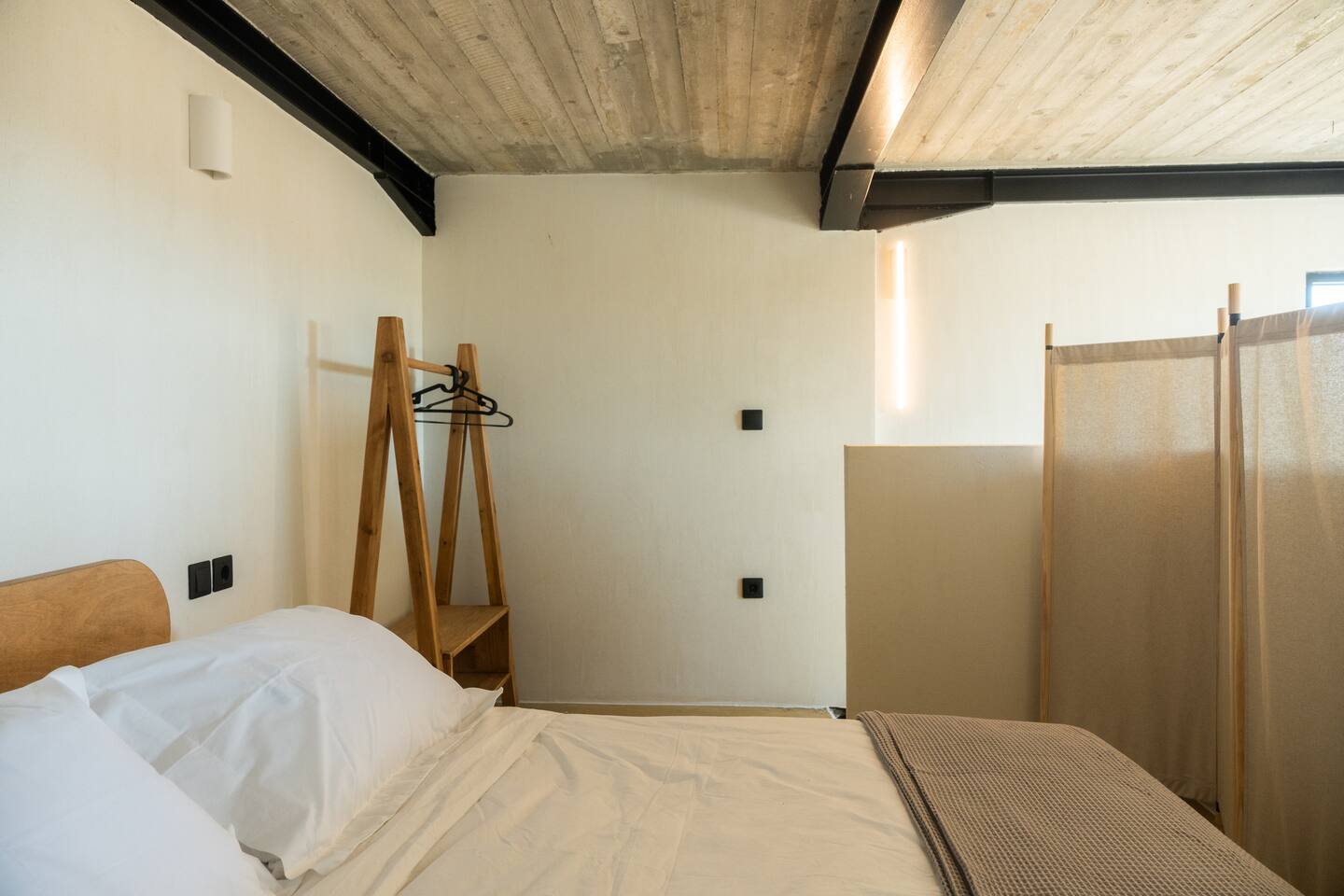 Bedroom alternate view with wooden hanger and screen divider