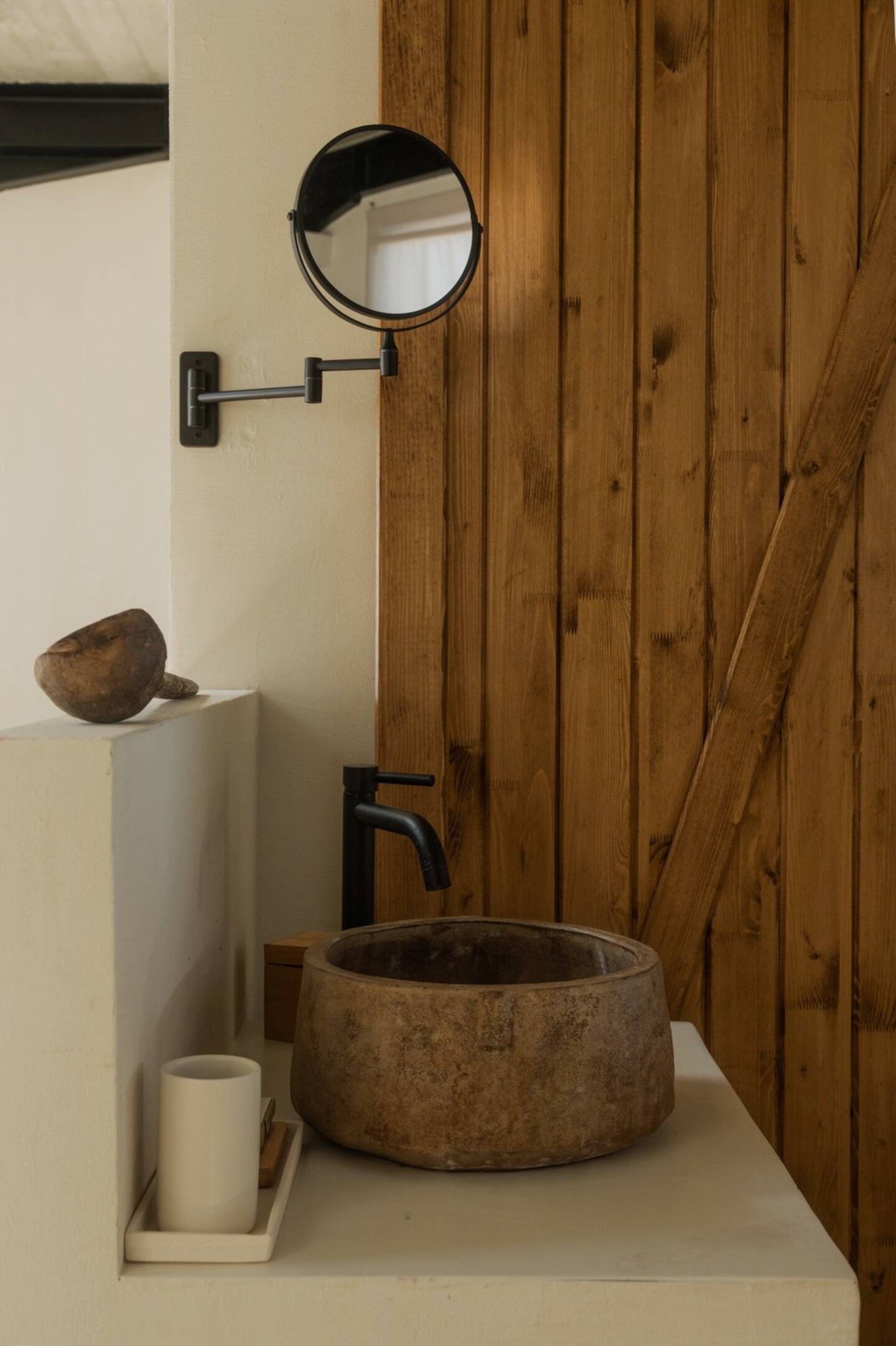 Bathroom detail — stone basin against wooden door background
